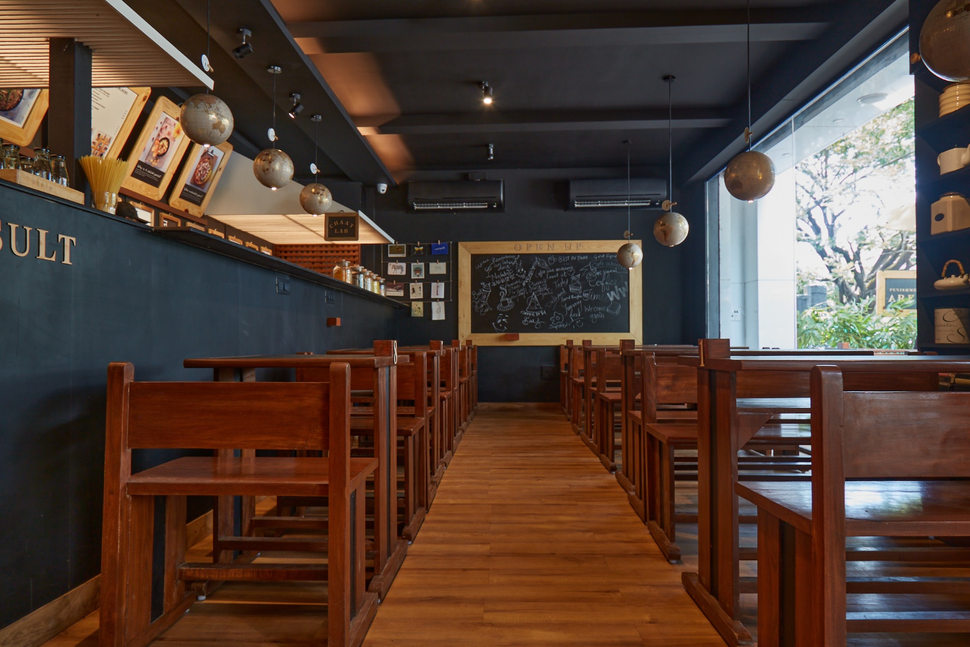 Café School Alibaug — themed café interior with chalkboard tables and warm school-inspired decor
